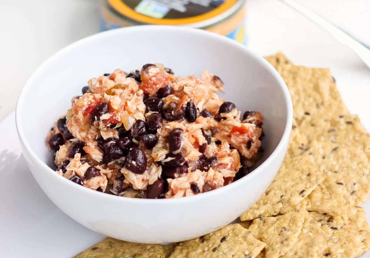 tuna salsa salad in a white bowl surrounded by crackers.