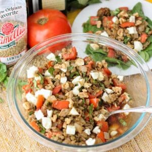 bag of lentils, fresh tomatoes, and a clear bowl with lentils, mozzarella, walnuts, tomatoes, and basil on a straw mat.