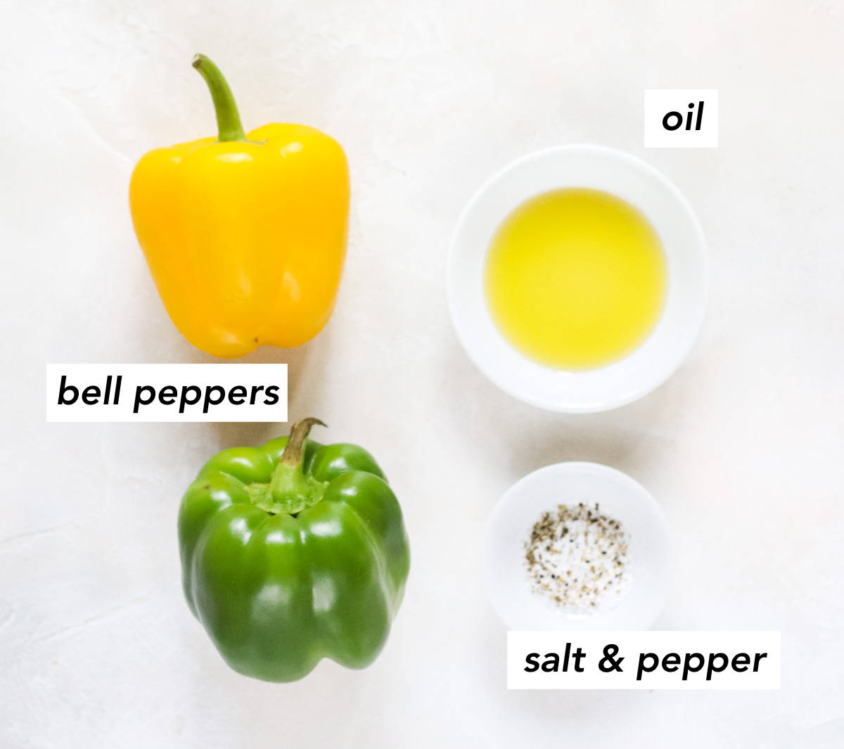 yellow bell pepper, green bell pepper, bowl of salt and pepper, and a bowl of olive oil on a white counter.
