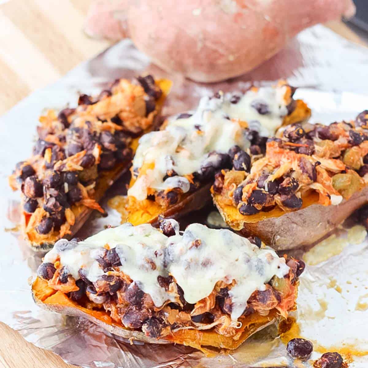 four cheese, bean, and chicken stuffed sweet potatoes on foil.
