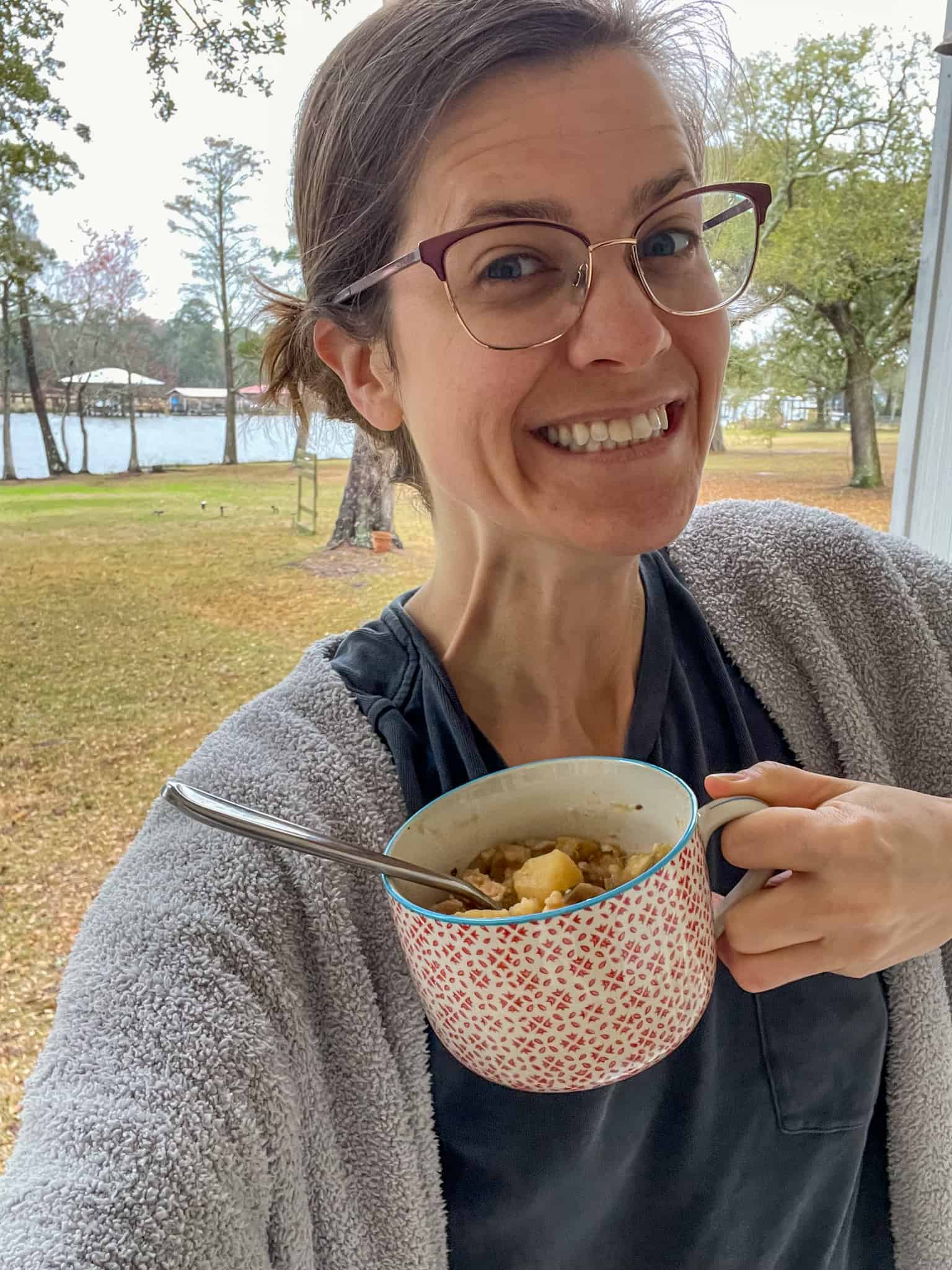 Meme with a silly smile holding a bowl of chicken hash and grits in a patterned bowl and a river in the background.