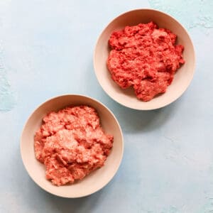 a bowl of ground beef and a bowl of ground lamb on a blue counter.