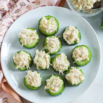 plate of chicken salad appetizers bites next to a silk scarf and a bowl of chicken salad.