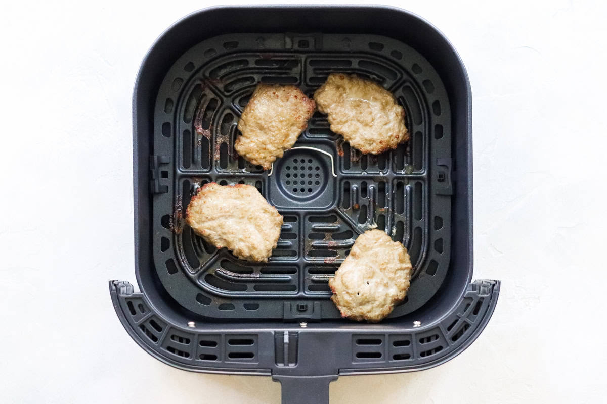 air fryer basket with cooked homemade breakfast sausage patties.