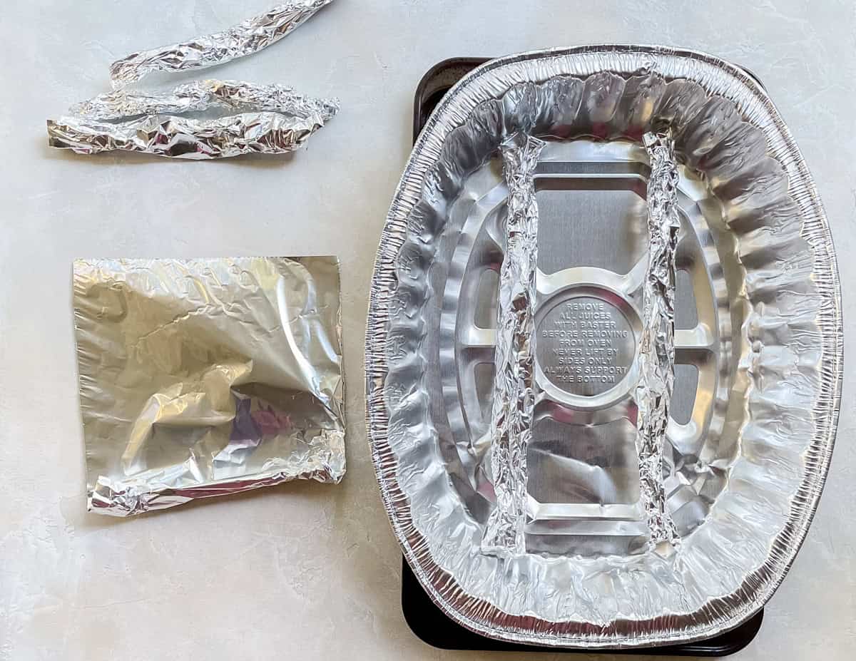 sheet of rolled foil next to a disposable roasting pan on a baking sheet.