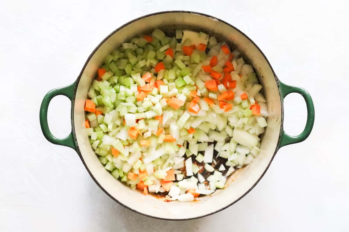 green pot with diced onions, celery, and carrots.