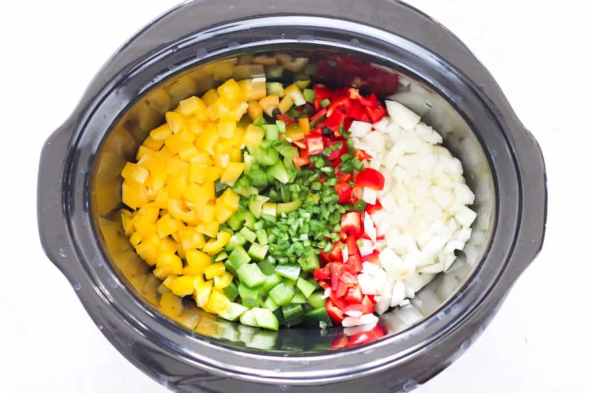 crock pot filled with diced bell peppers, onions, and jalapenos.