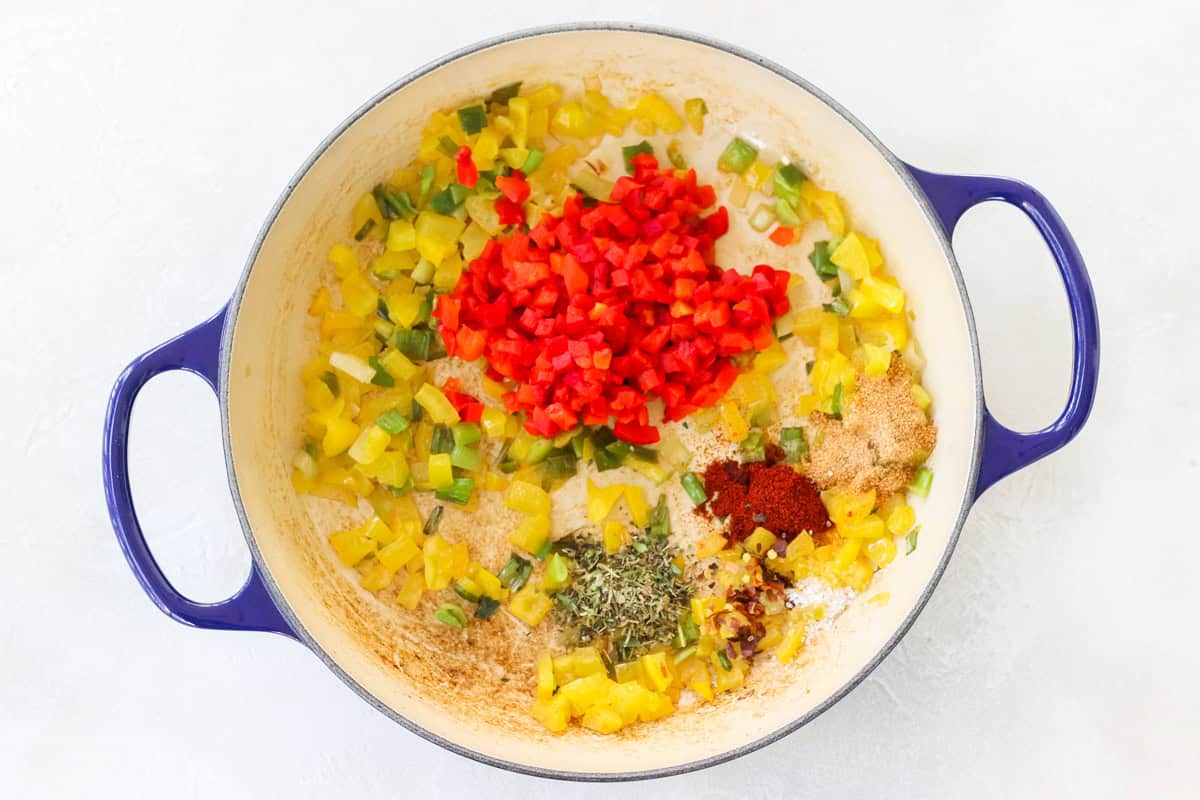 blue pan with sauteed bell peppers and green onions with pimentos, spices, and salt.