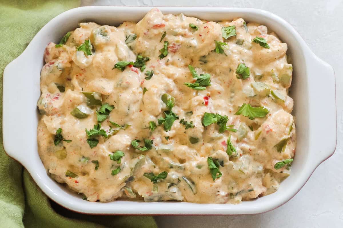 hot crawfish dip in a baking dish next to a green napkin.
