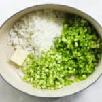 blue pot with butter, diced celery, onions, and bell peppers.