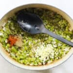 pot with sauteed celery, onions, and green bell peppers with cayenne pepper, dried thyme, and fresh garlic.