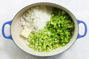blue pot with butter, diced celery, onions, and bell peppers.