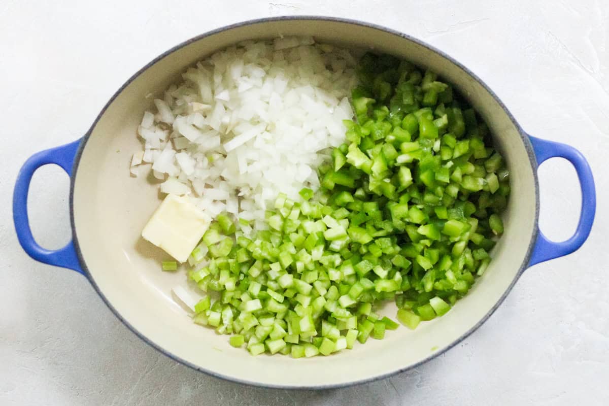 blue pot with butter, diced celery, onions, and bell peppers.
