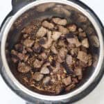 browned beef in the bottom of the instant pot.