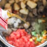 beef broth being poured into an instant pot to make beef vegetable soup.