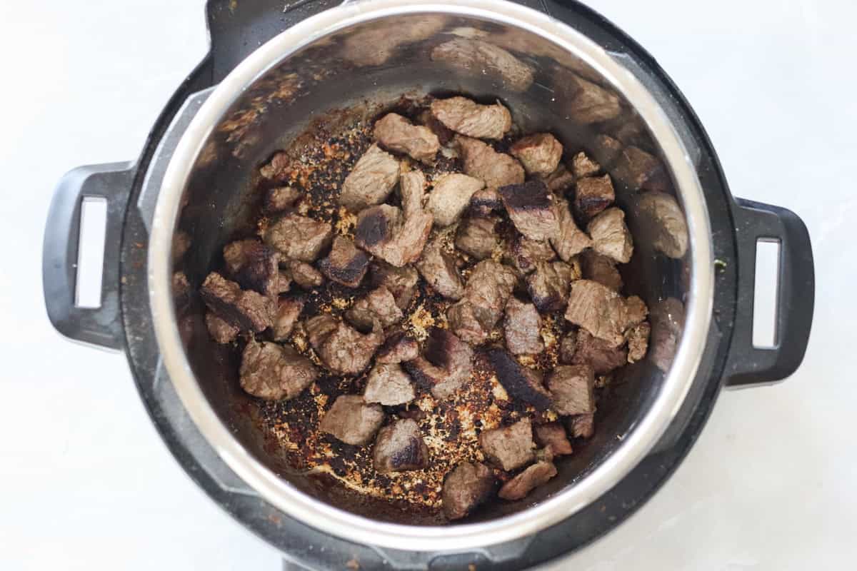 browned beef in the bottom of the instant pot.