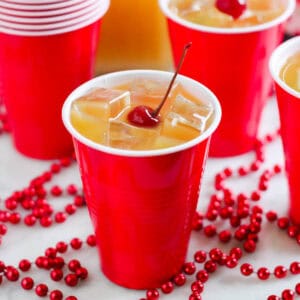 red cup with yellow hammer drink with cherry on top and red beads.