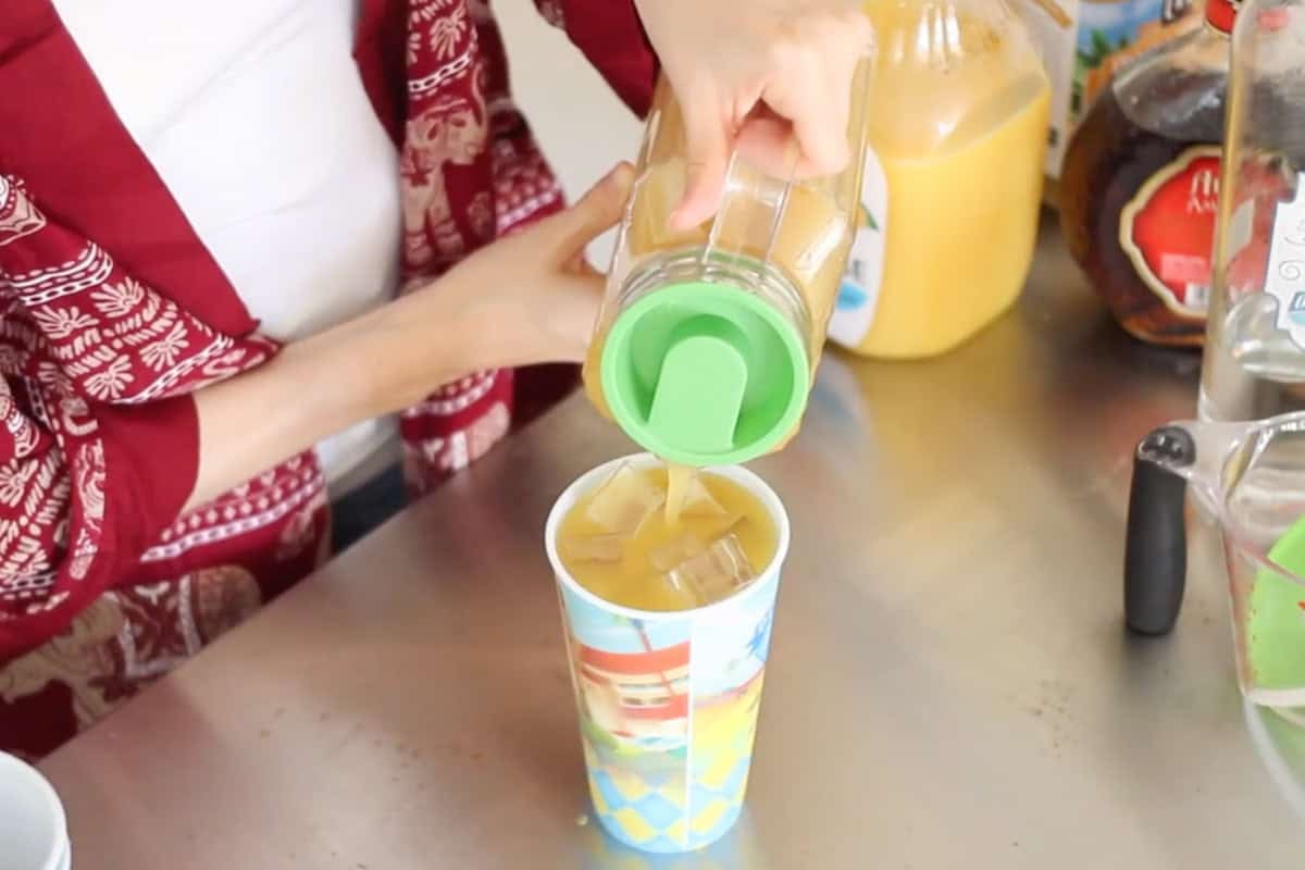 yellow hammer drinks being poured into a cup of ice.