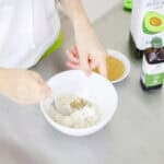 hand stirring dry ingredients into a bowl for a microwave cookie.