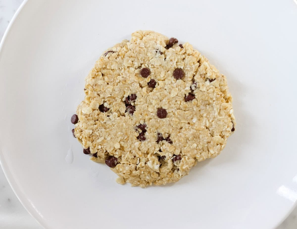 white plate with cookie dough before microwaving.